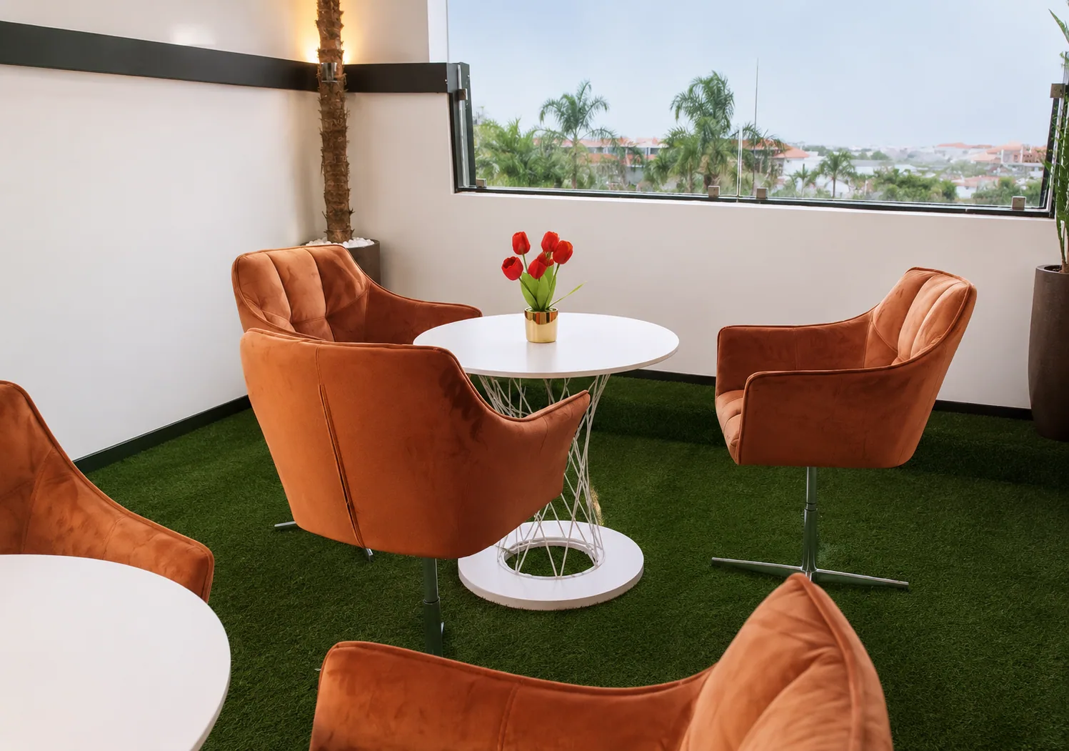 Zona luminosa de coworking GBC com mesas brancas e vista sobre Luanda