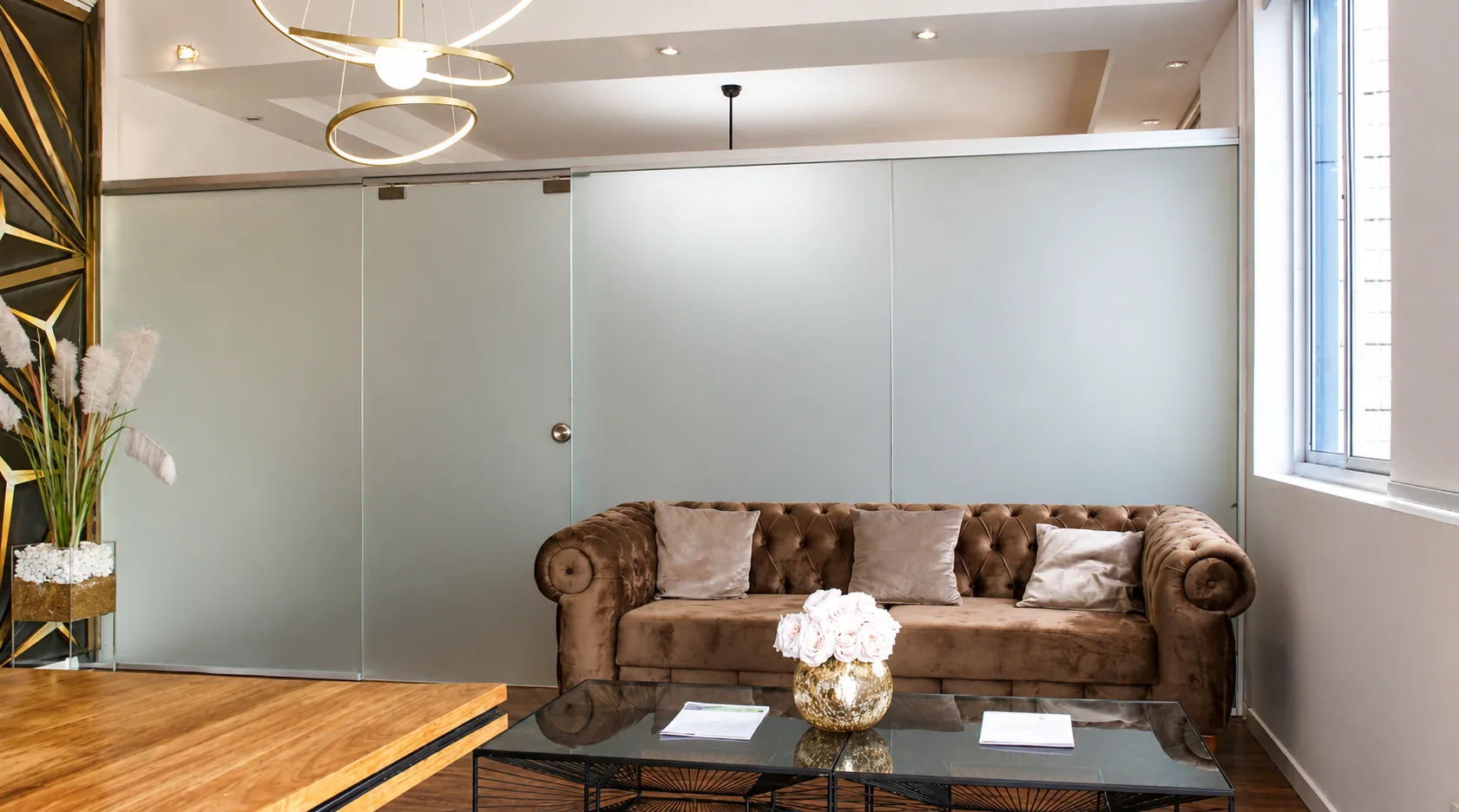 Lounge privado GBC com sofá, mesa de vidro e parede de vidro fosco